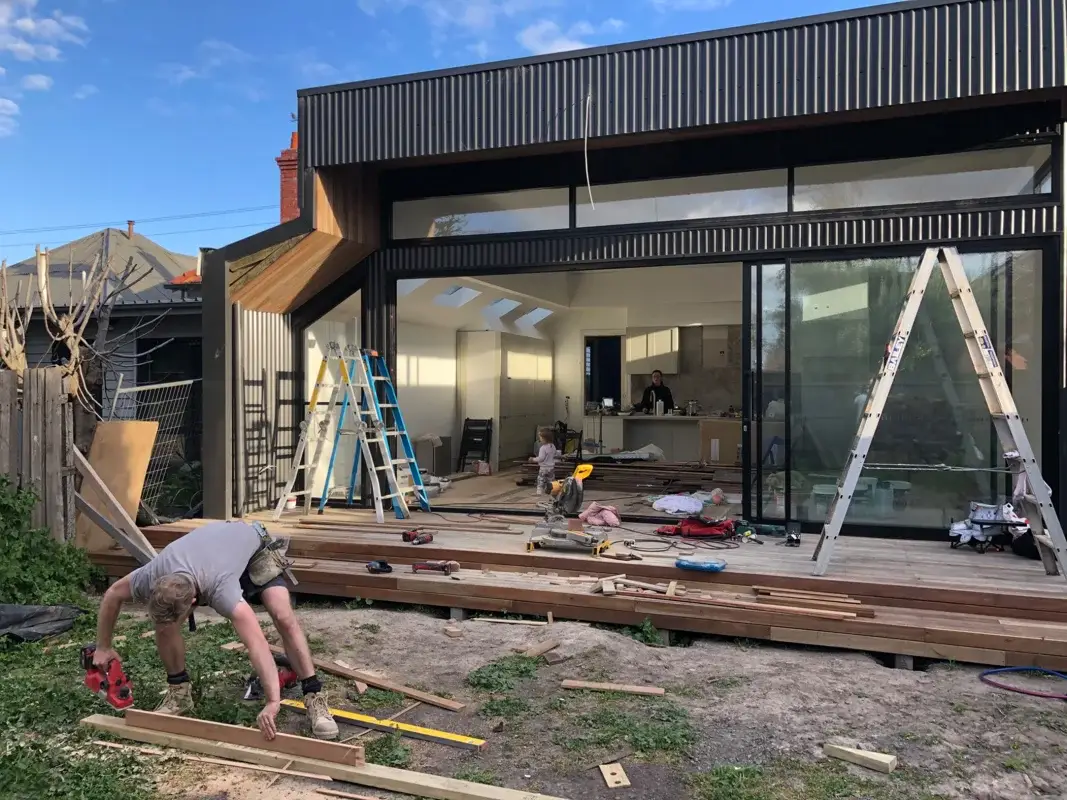 Outdoor space and deck under construction with family in background